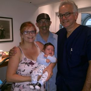 Dr. Paul Gindoff with a family holding their baby.