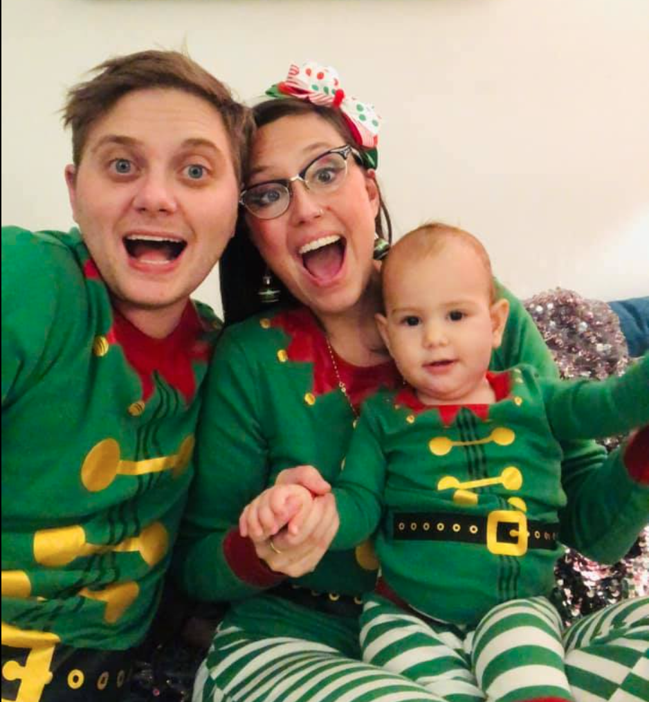 Couple in holiday costumes holding their newborn baby