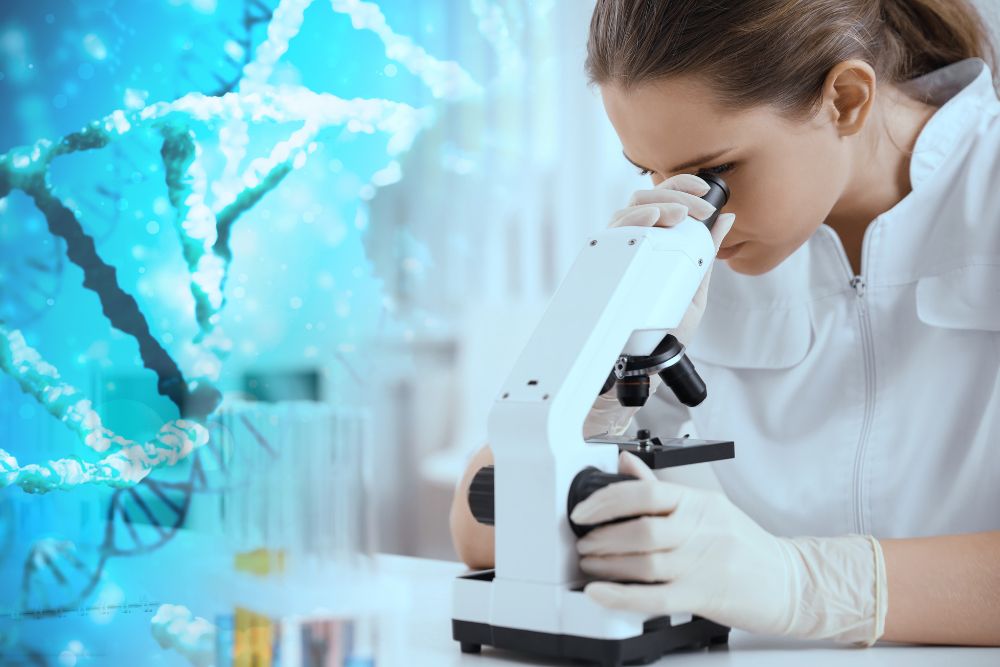 A lab worker looking into a microscope