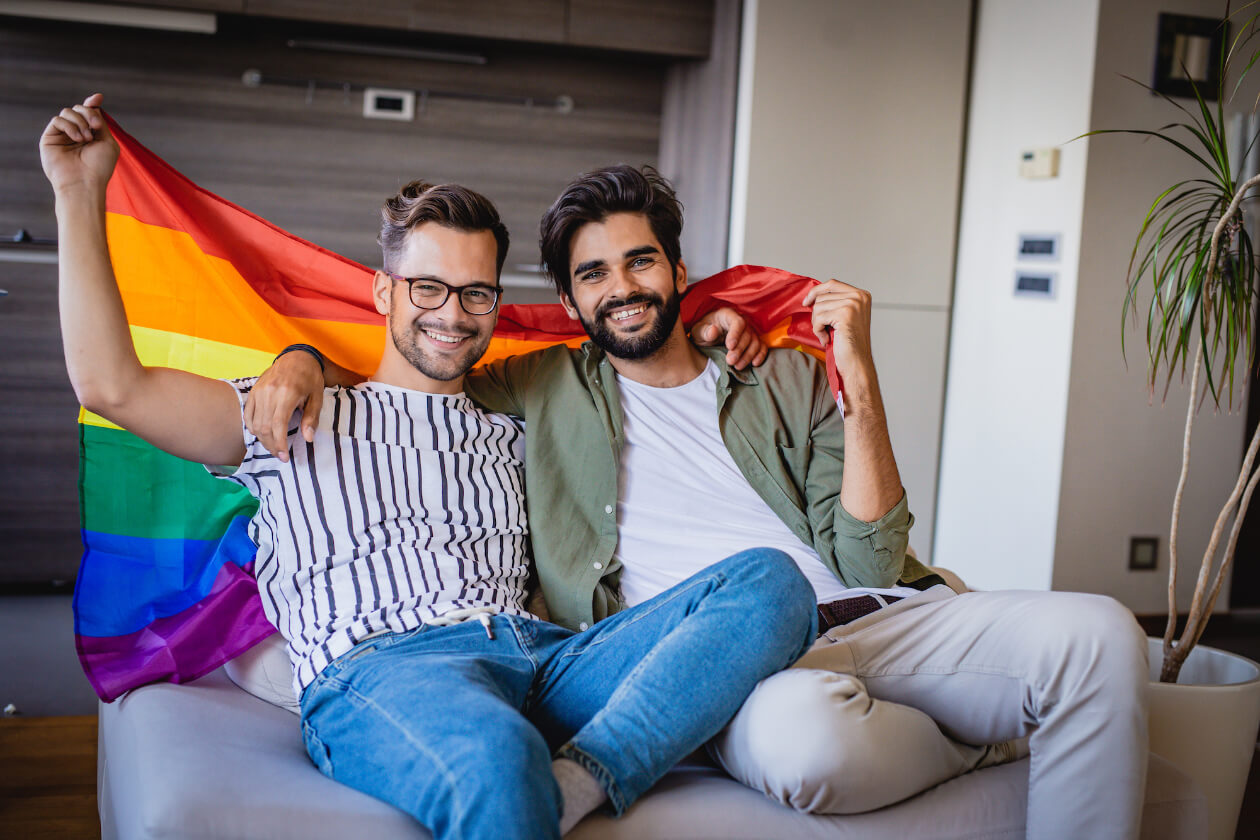 Two men of the LGBT community holding a gay pride flag