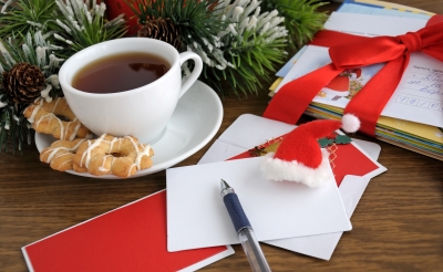 a stack of holiday cards next to a cup of coffee