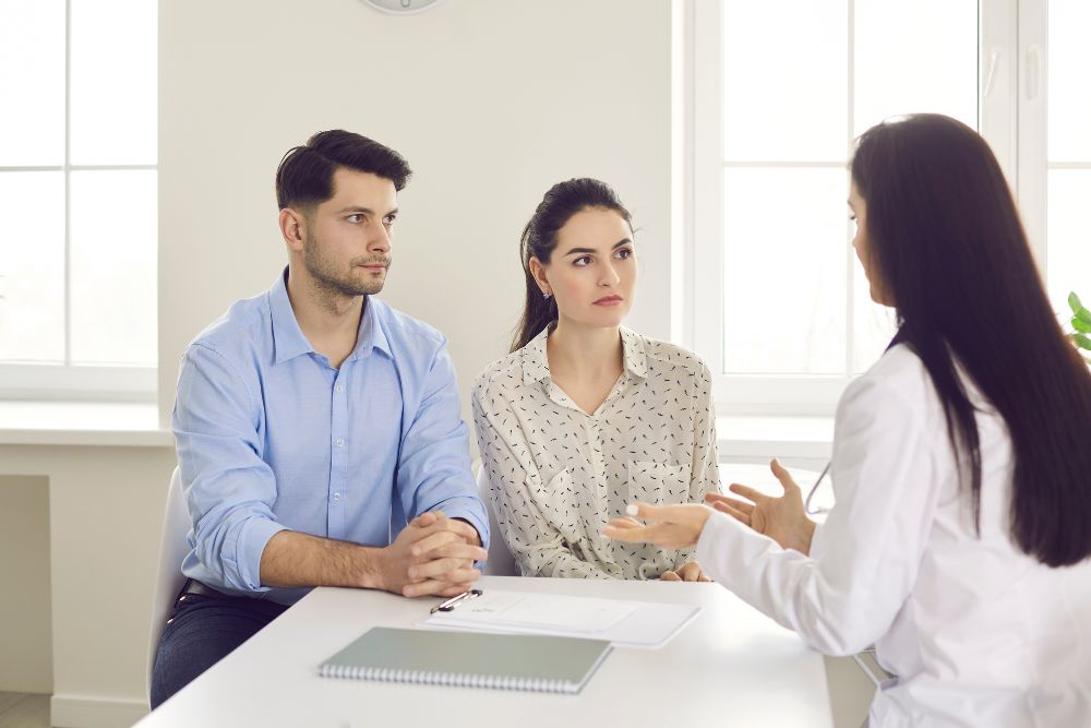 a Couple listening attentively at their fertility specialist