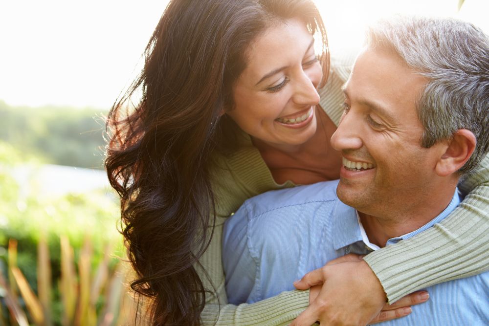 A couple embracing on a field in broad daylight