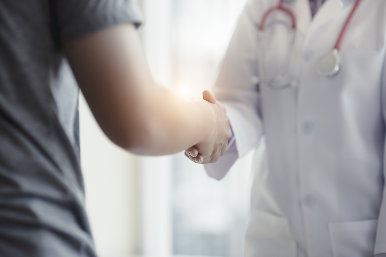 A female patient shakes hands with a fertility specialist