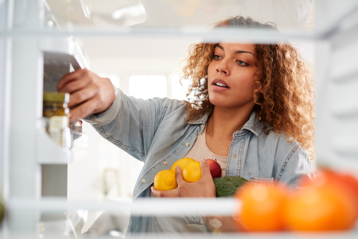 Female grabbing items from her fridge