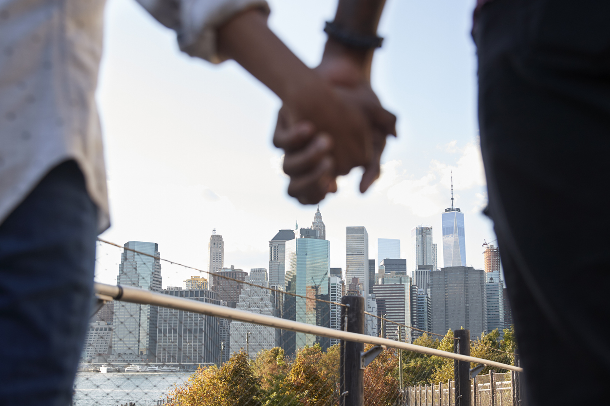 Couple holding hands with the new york skyline in the background