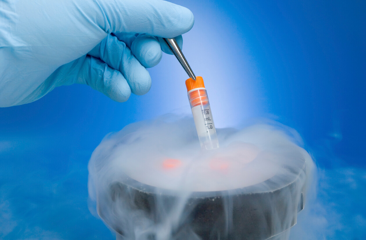 Embryologist placing a tube in liquid nitrogen