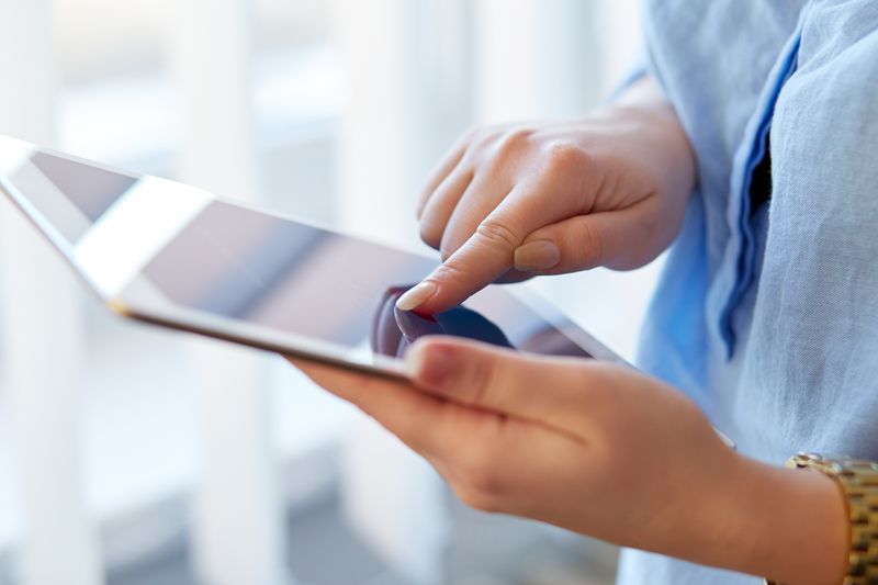 A female patient with her finger on a tablet