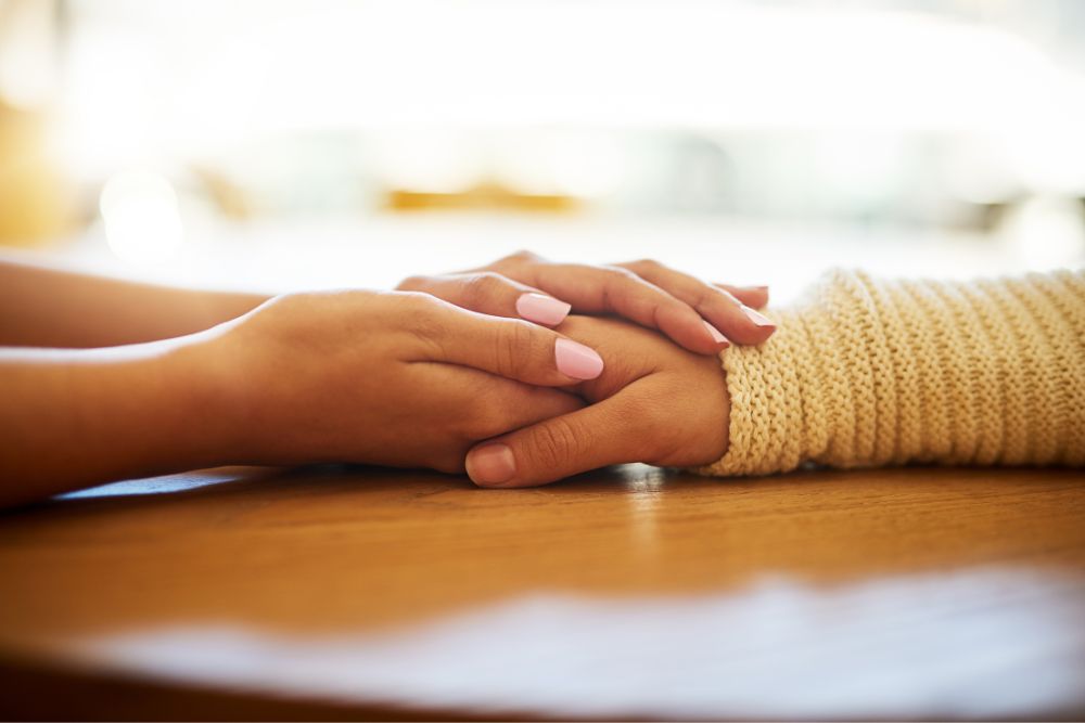Two females holding hands on top of a table