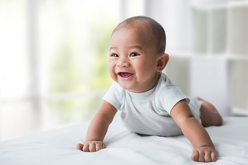 Baby crawling on a bed